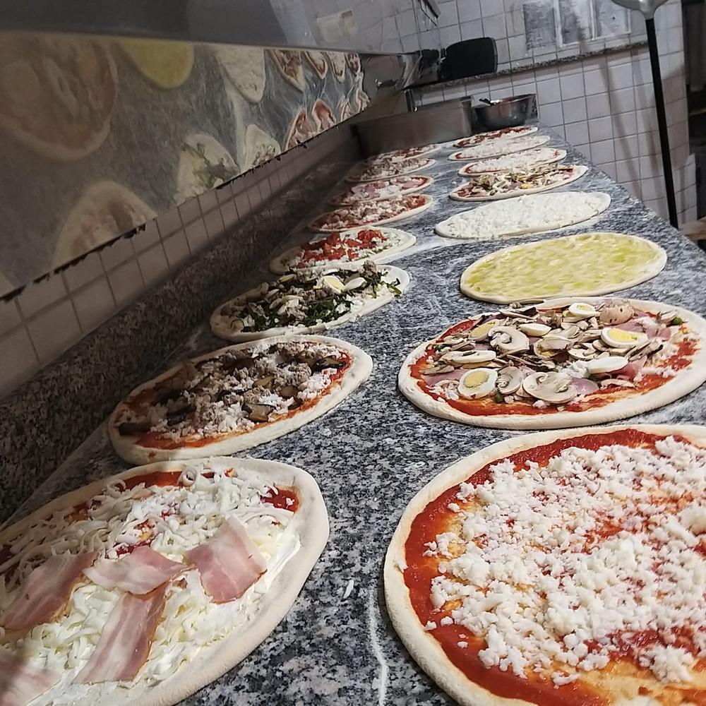 Pizze pronte per il forno sul banco