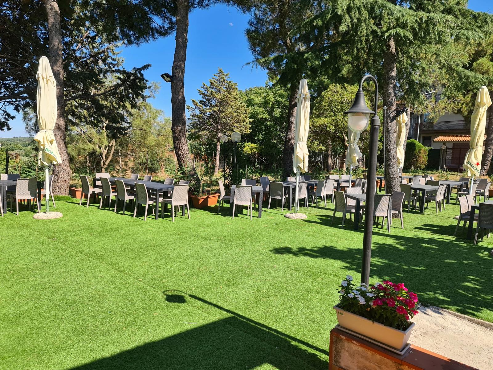 Il giardino all'aperto del Royal con i tavoli tra gli alberi